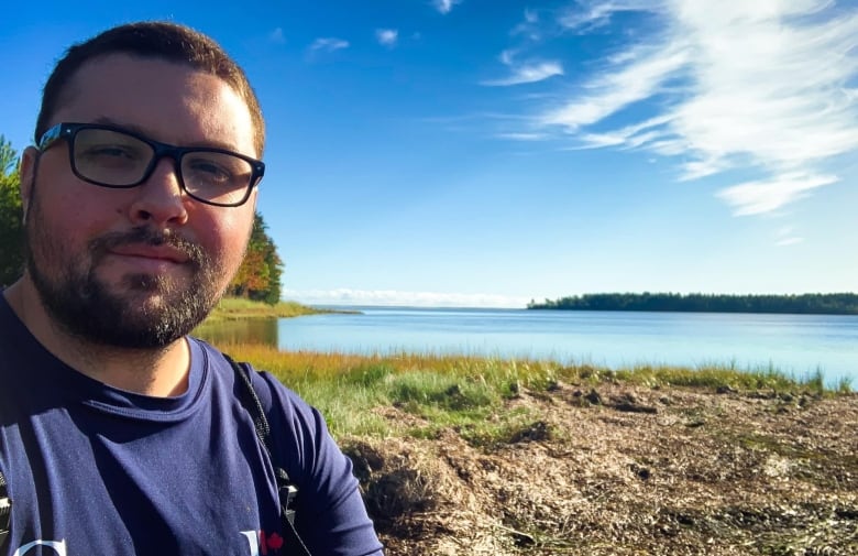 Jeff Clements in Canada t-shirt beside body of water