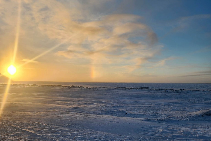 The sun sets over ice. 