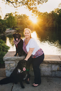 Dog trainer Kate LaSala poses for a photo with her two dogs by a river