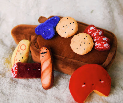 The barkcuterie toy features a squeaky board with soft toys for dogs