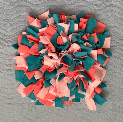 A dog snuffle mat in shades of pink and green