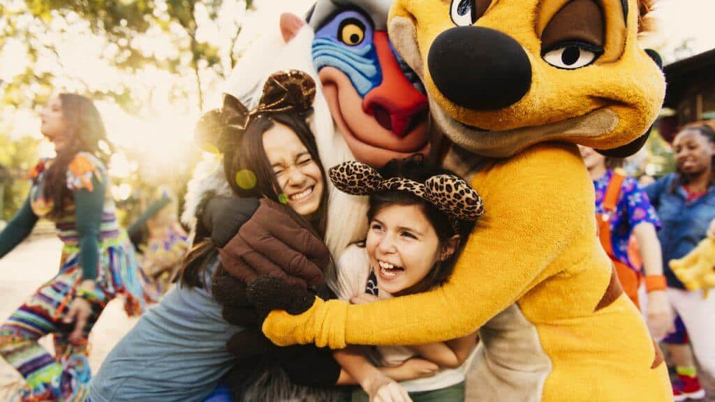 Timon and Rafiki hug two female Guests