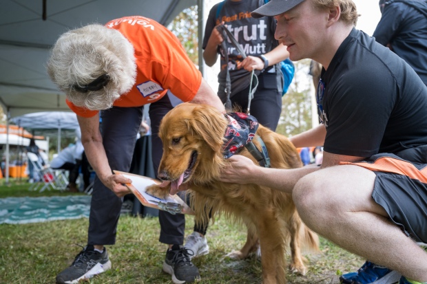 Volunteer Terry Finkelstein, left, gets a painted paw print from...